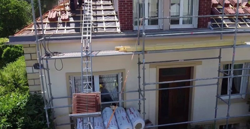 Toiture en tuiles d'une maison en travaux de réfection réalisée par une équipe de couvreurs