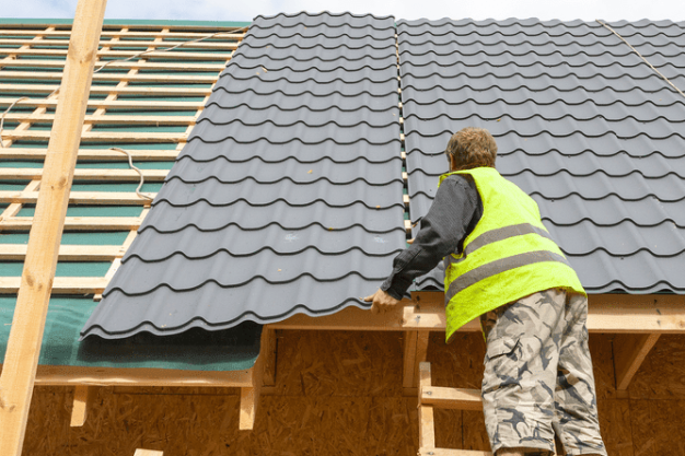 Couvreur posant une toiture imitation tuiles