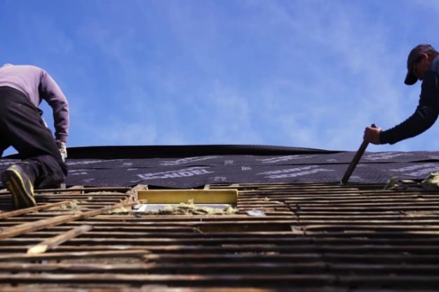 Des couvreurs en intervention sur une toiture en réfection